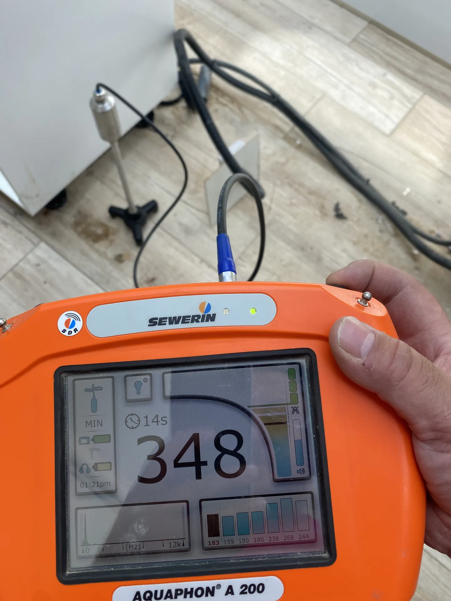 Acoustic leak detector showing a peak reading of 348 as the microphone passes over the leak