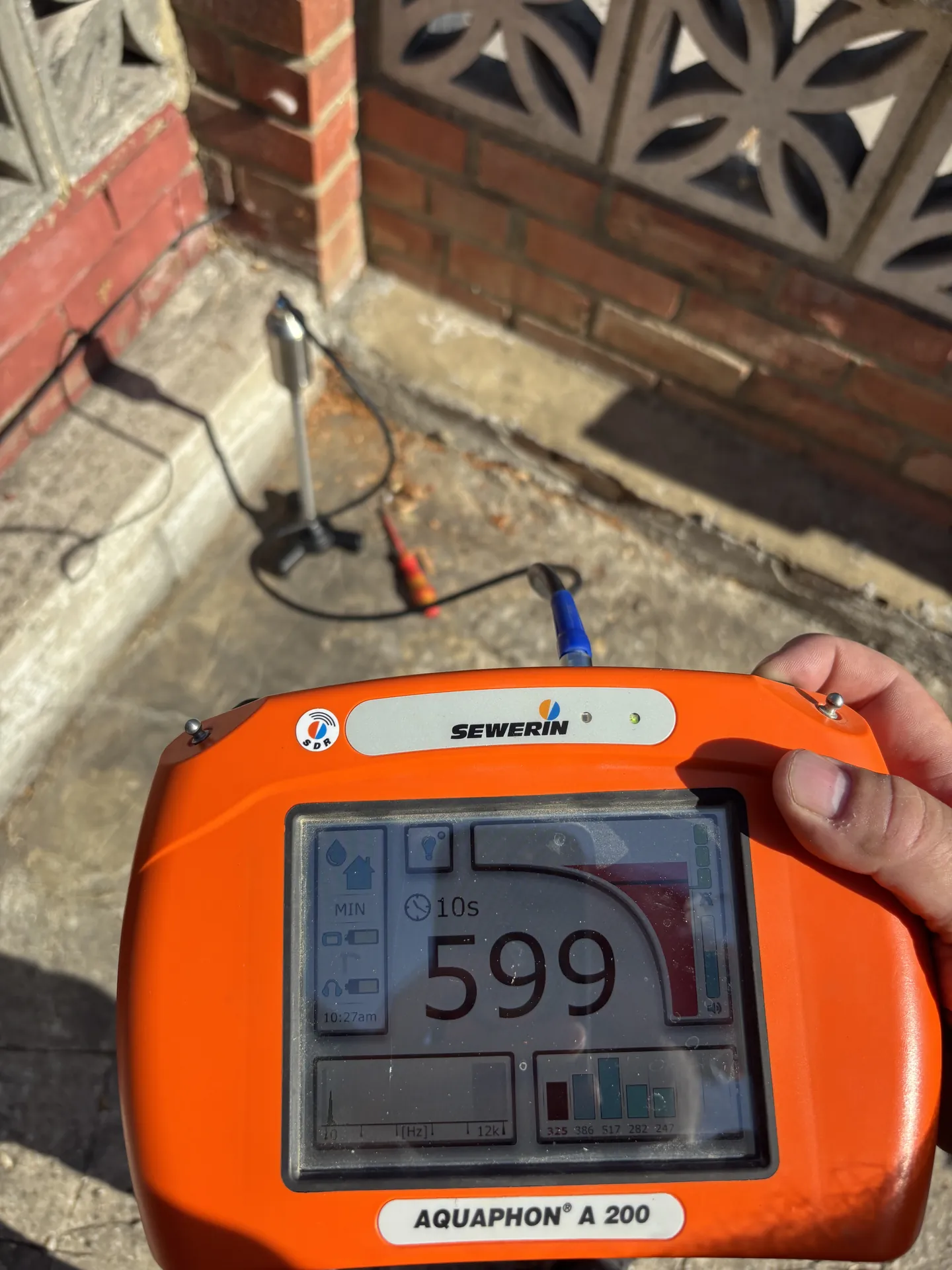 Acoustic leak detector reading 599 against an outside wall on a mains water leak