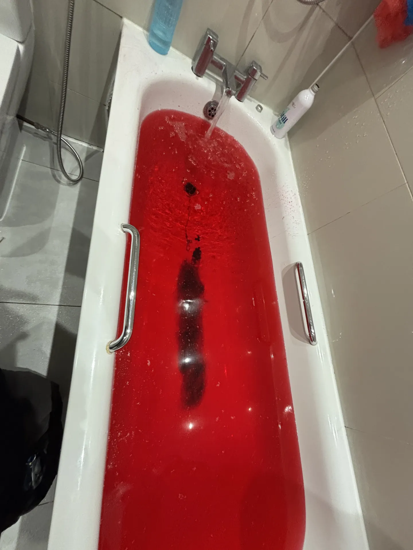Bath filled with red dye during a bathroom leak test