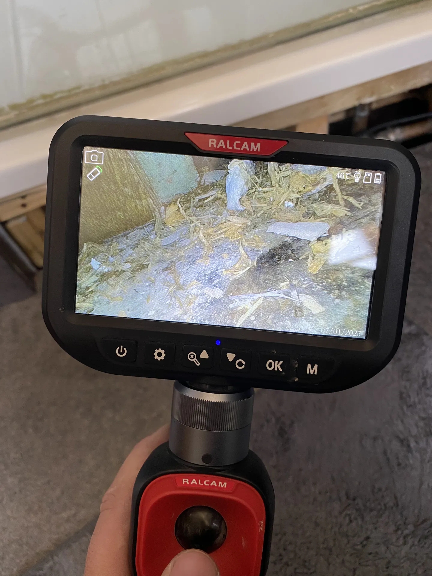 Borescope camera screen showing the void under a floor