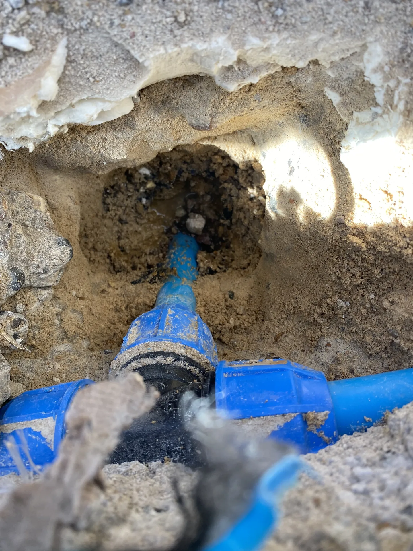 Blue MDPE water main joint found leaking in an excavation
