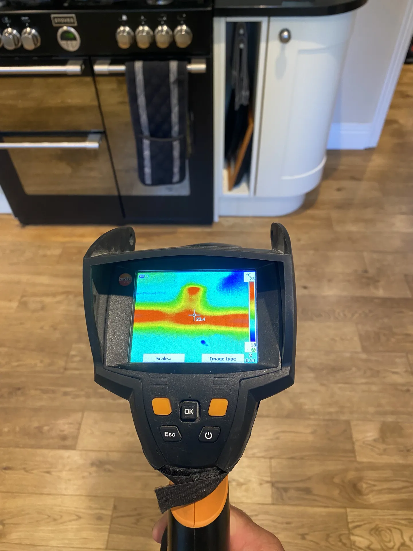 Thermal camera showing a hot spot on a kitchen floor in front of the cooker