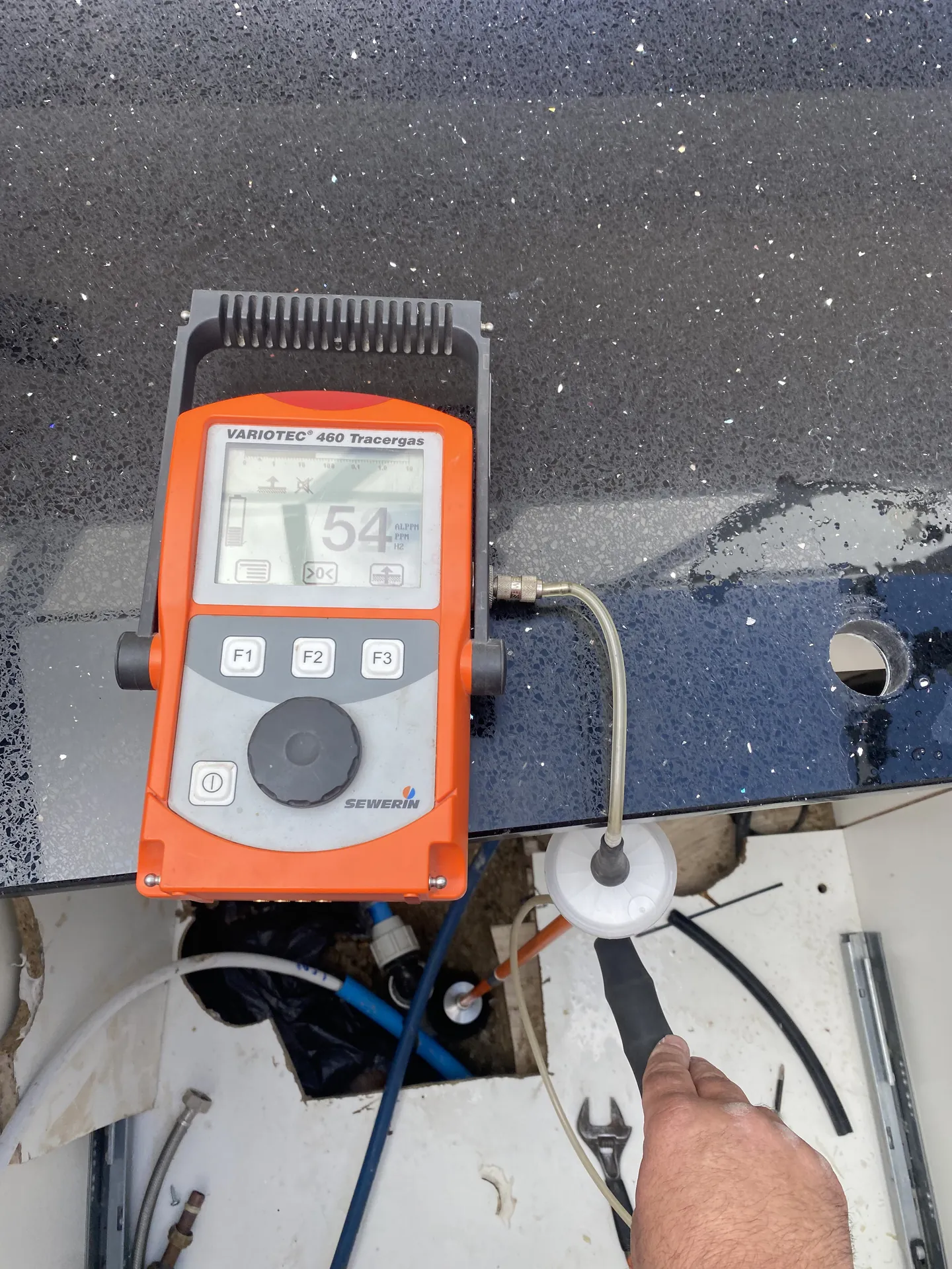 Tracer gas detector reading through a small opening in a kitchen worktop