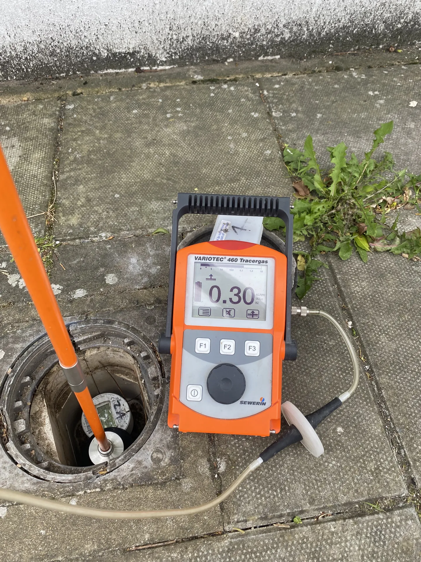 Tracer gas detector at an outside drain checking a buried pipe