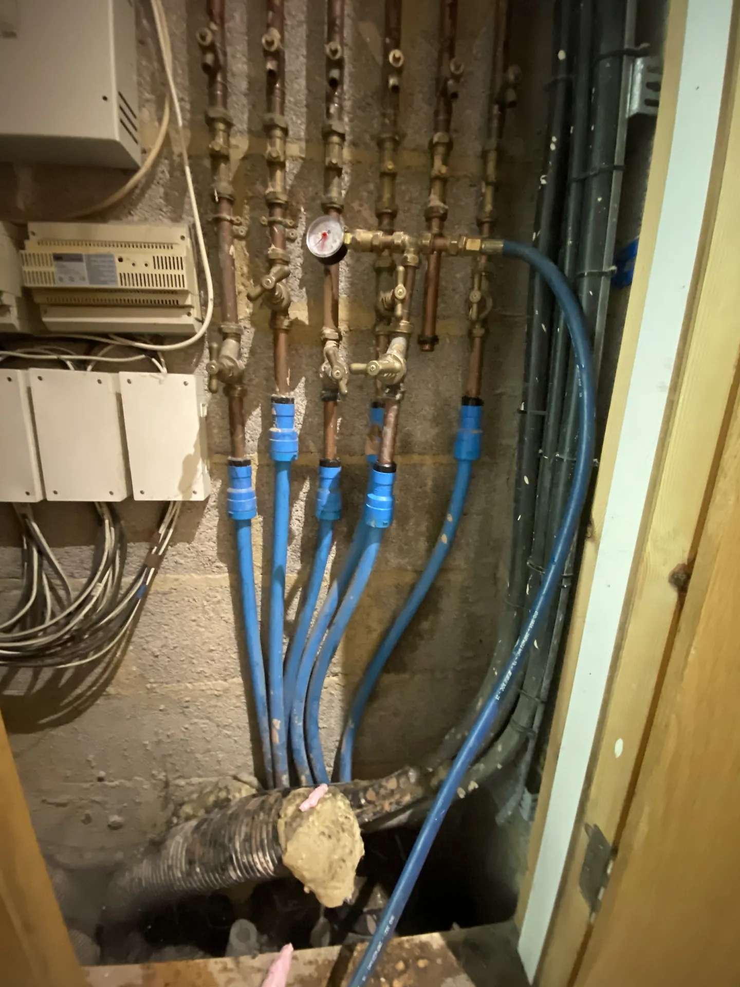Underfloor heating manifold with blue pipes during a leak test